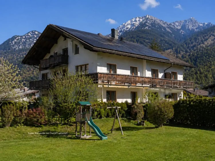 Mehrfamilienhaus mit großem Garten und einer PV-Anlage am Dach
