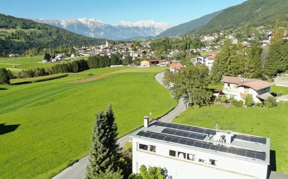 Drohnenshot von einem Haus mit PV-Anlage am Dach aus der Ferne