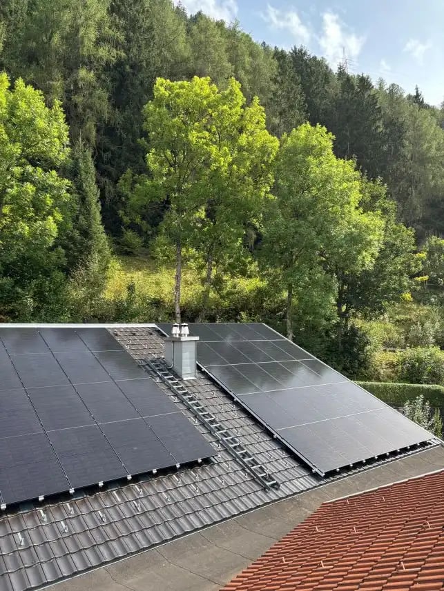 Satteldach mit PV Anlage und Wald im Hintergrund