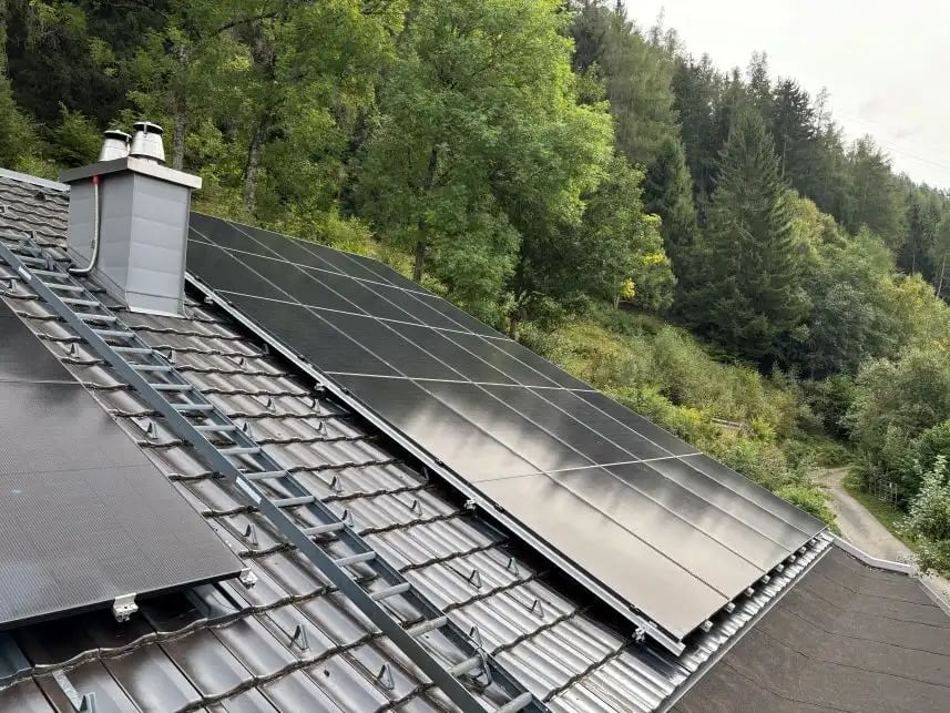 Satteldach mit PV Anlage und Wald im Hintergrund