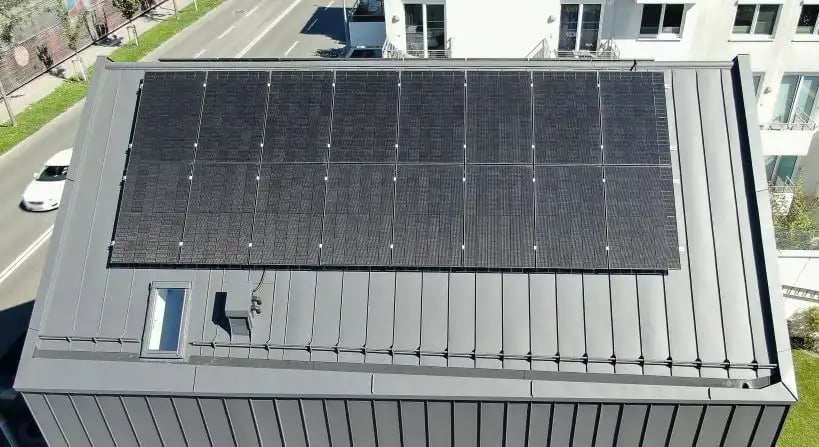 Hausdach mit PV Anlage neben einer Straße 