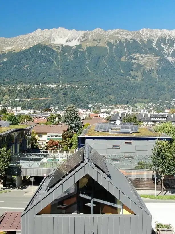 Einfamilienhaus mit PV Anlage am Dach von vorne fotografiert mit Nordkette im Hintergrund 